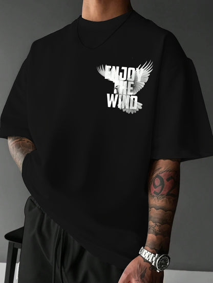 Person wearing a black t-shirt with 'Enjoy the Wind' design on a gray background