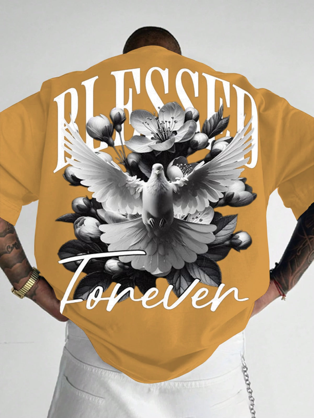 Person wearing a mustard yellow t-shirt with a graphic design and text on the back.