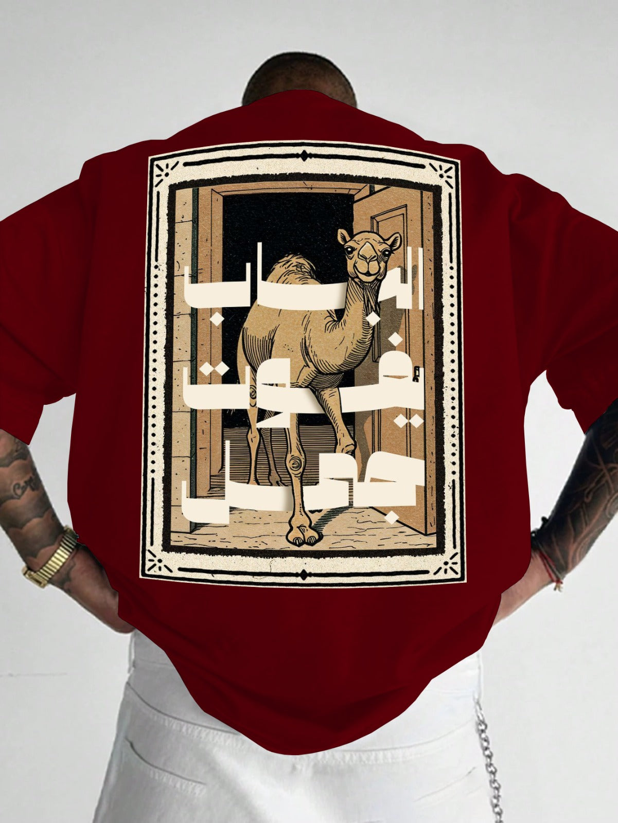 Person wearing a red shirt with a camel design on the back against a white background