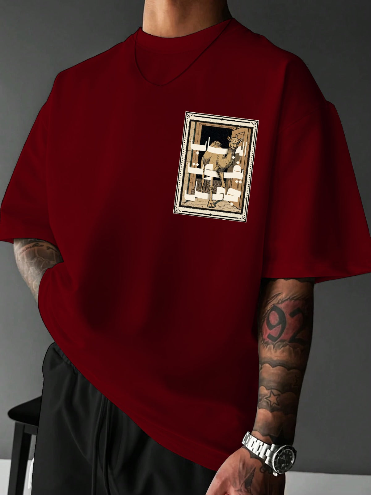 Person wearing a red t-shirt with a graphic design on a gray background