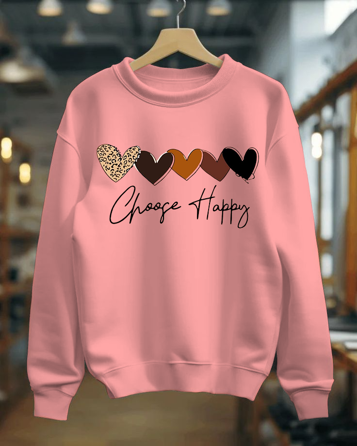 Pink sweatshirt with heart designs and 'Choose Happy' text on a hanger.