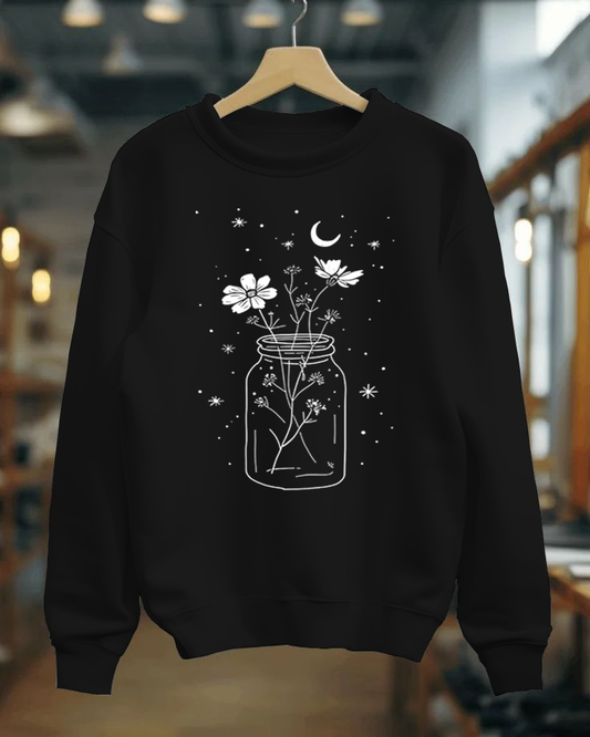 Black sweatshirt with a jar of flowers design on a hanger against a blurred indoor background