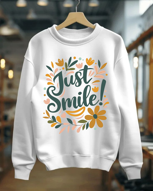 White sweatshirt with 'Just Smile!' text and floral designs on a hanger.