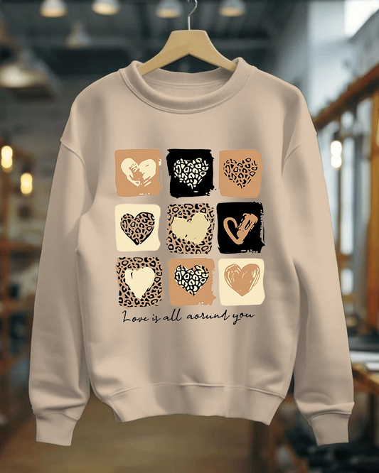 Beige sweatshirt with heart and animal print pattern on a hanger
