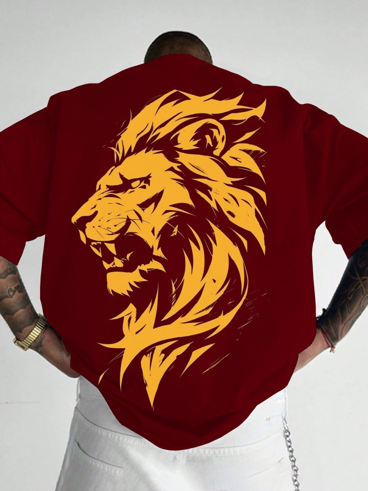 Red t-shirt with a yellow lion graphic on the back, worn by a person.