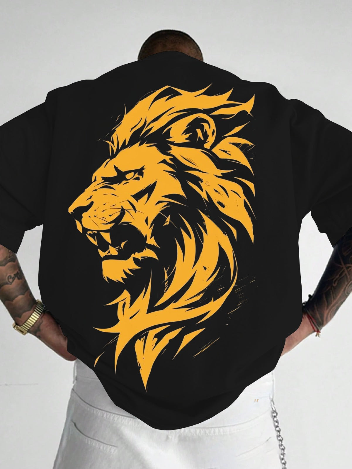 Person wearing a black shirt with a yellow lion design on the back against a white background