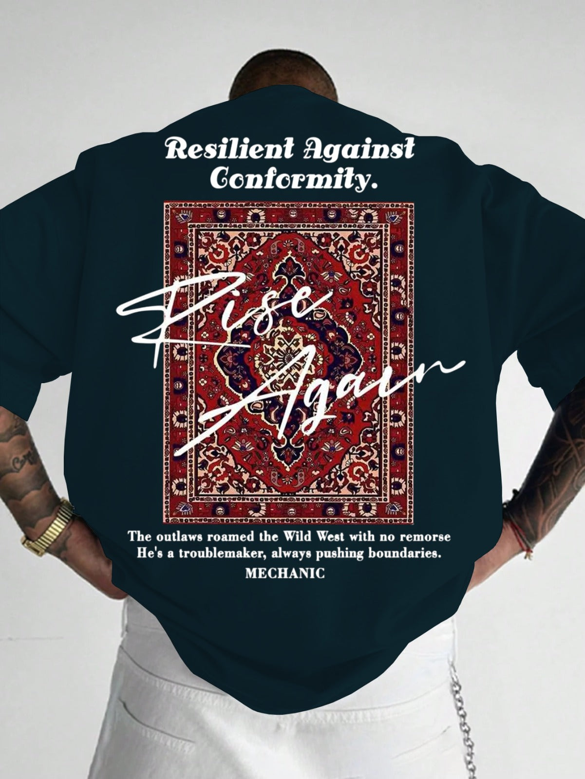 Person wearing a dark blue shirt with text and a pattern on the back, standing against a plain background.