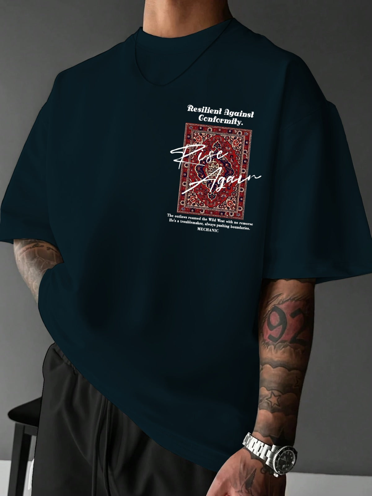 Person wearing a black t-shirt with a graphic design and text on a gray background