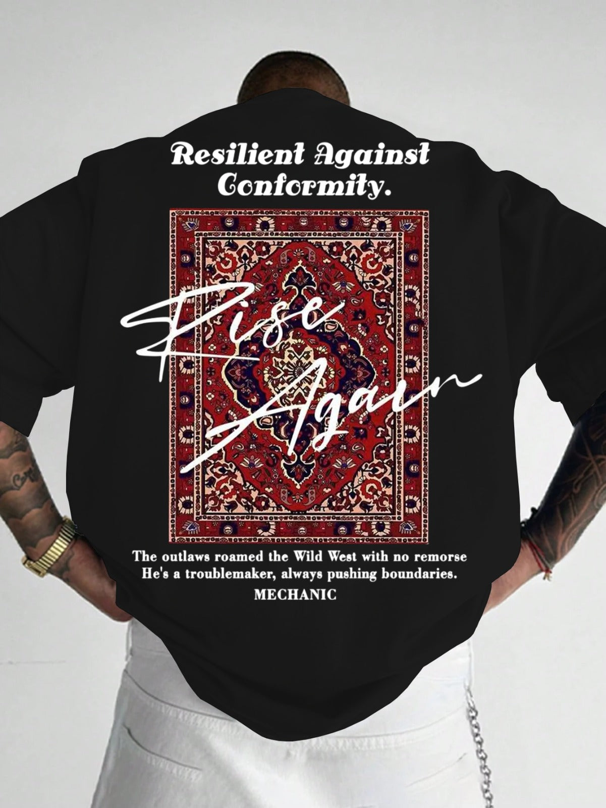 Person wearing a black t-shirt with a graphic and text on the back, standing against a white background.