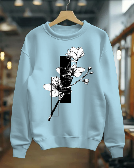 Light blue sweatshirt with floral design on a hanger in a blurred indoor setting