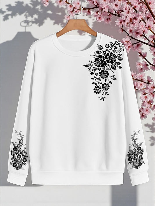 White sweatshirt with black floral embroidery on a hanger against a cherry blossom background
