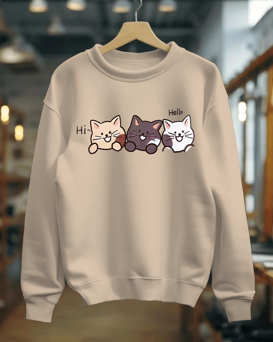 Beige sweatshirt with cartoon cat designs and text on a hanger.