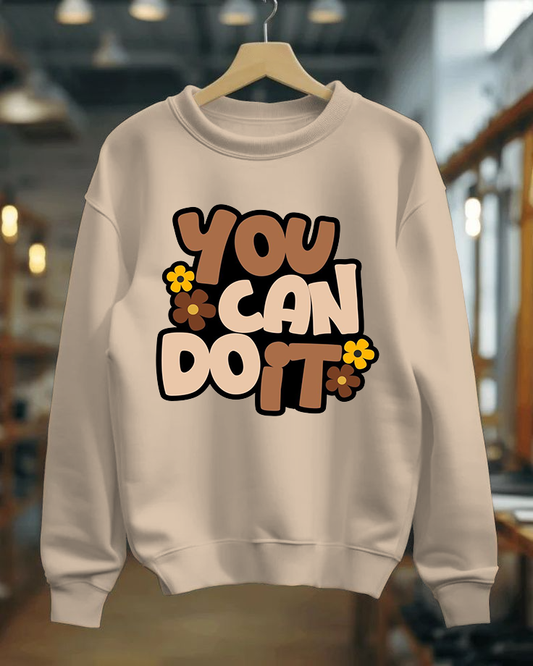 Beige sweatshirt with 'You Can Do It' text on a hanger in a store setting