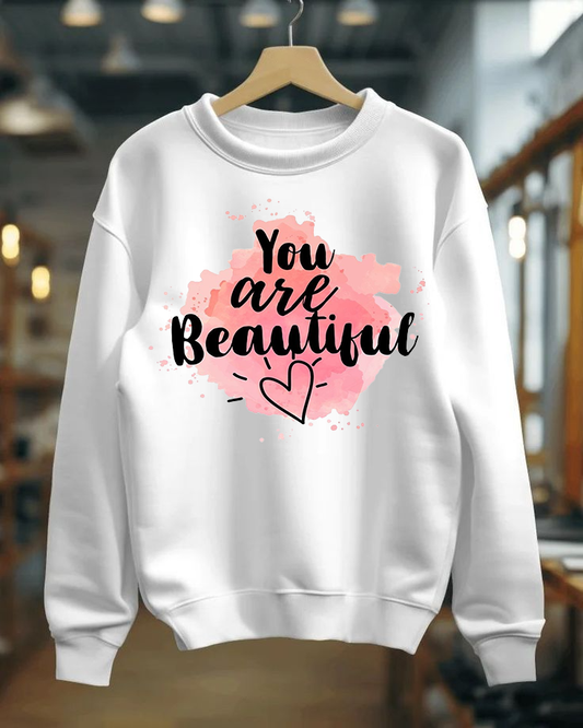 White sweatshirt with 'You are Beautiful' text and pink heart design on a hanger.